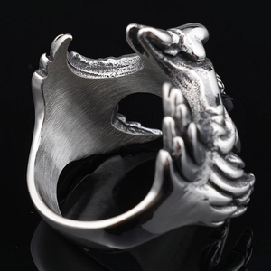 Macro detail of gothic stainless steel ring featuring vintage dragon relief and brushed metal