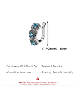 Macro detail of silver zinc alloy C-shaped ear cuff with blue gems and small diamonds