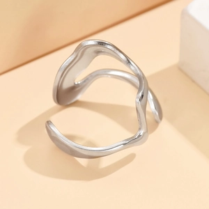 Irregular wavy silver open ring with a modern geometric design on stone background