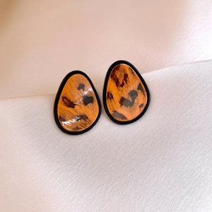 Detailed view of caramel leopard print resin earrings with elegant black borders