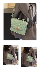Detail of mint green quilted crossbody bag featuring a golden circular twist-lock clasp