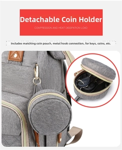 Detail view of a grey quilted diaper bag with a detachable round coin pouch for keys