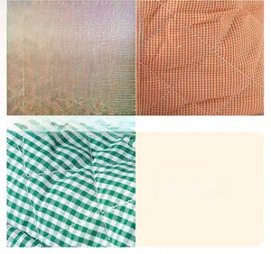Detail view of high-quality quilted fabric with fine stitching in orange and green plaid