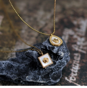 Detailed macro view of vintage gold crown and rose pendants on textured black rock