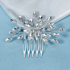 Peigne à cheveux de mariée argenté avec fleurs en cristal marquise sur marbre et tissu bleu