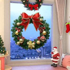 Detail of Christmas wreath with red bow and gold ornaments on a snowy window