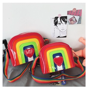Close-up of rainbow heart crossbody bags with glossy patent finish and striped design