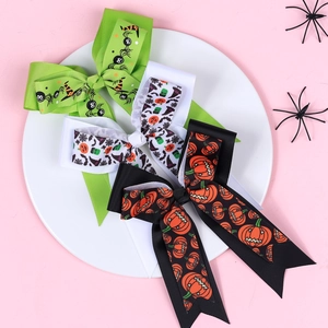 Close-up of Halloween bows featuring pumpkin and spider patterns on a white plate