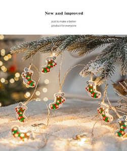 Detail of warm white LED Christmas stocking string lights hanging on snowy pine branches