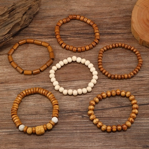 Detailed overhead view of various handmade wooden bead bracelets in natural earthy tones