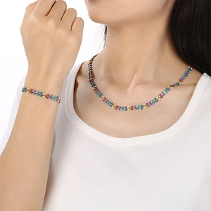 Close-up of model wearing colorful enamel leaf-shaped necklace and bracelet jewelry set