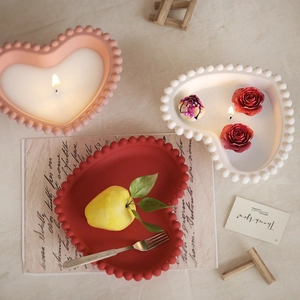 Top view of heart-shaped candle jars with beaded edges in pink, white, and red matte finish