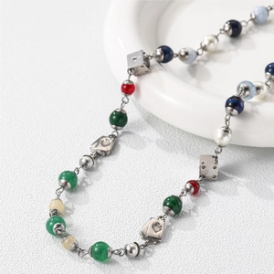 Macro shot of titanium steel necklace featuring dice charms and colored natural stone beads