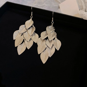 Detailed view of silver multi-layered leaf tassel earrings on elegant black gift packaging