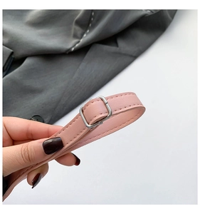 Close-up of pink leather strap with polished silver metal buckle on a shoulder bag