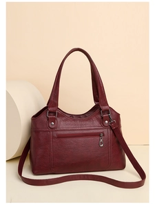 Détail du sac cabas bordeaux avec texture cuir grainé et bandoulière réglable