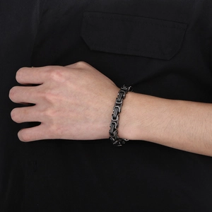 Detail of masculine Byzantine stainless steel chain bracelet on a male wrist