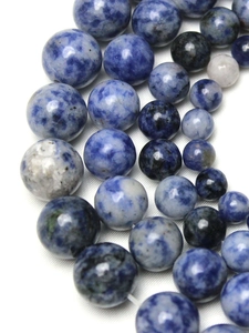 Macro detail of round blue sodalite stone beads with natural white and grey veins