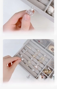 Detail of transparent jewelry box with crystal handle and grey flocked ring tray