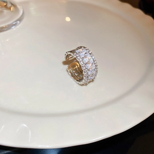 Detailed close-up of a silver zircon ring with rectangular cut stones on a white tray