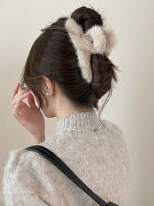 Vue détaillée d'un modèle portant la grande pince à cheveux en peluche beige en vison