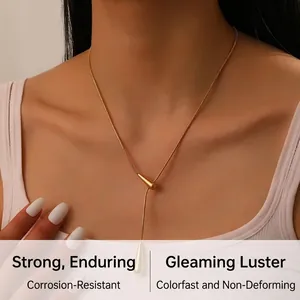 Close-up of golden stainless steel Y-shaped lariat necklace with teardrop pendant charm