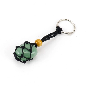Detailed view of natural green raw stone wrapped in black woven mesh for keychain