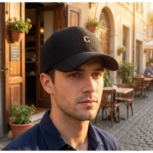 Detailed close-up of charcoal herringbone wool baseball cap with gold metal C letter logo