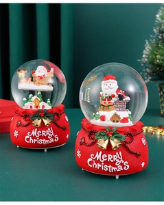 Detail of Christmas crystal ball featuring Santa Claus and reindeer on a red base