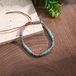 Detail of adjustable beaded bracelet with turquoise stones and silver beads on wood