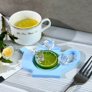 Morandi blue teapot shaped silicone coaster on wooden table for elegant tea time