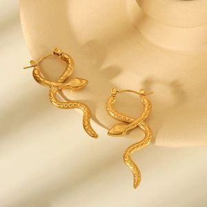 Elegant 18k gold plated snake textured hoop earrings on a beige ceramic dish