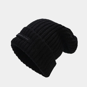 Textura detallada del gorro de punto negro con etiqueta de logotipo minimalista