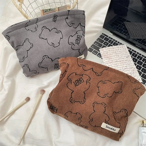 Macro detail of corduroy makeup bag with cute bear print and soft fabric texture