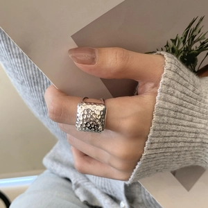 Detailed view of square hammered texture on sterling silver ring worn by a model