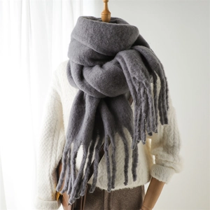 Gros plan d'une écharpe en mohair gris foncé épaisse avec de longues franges