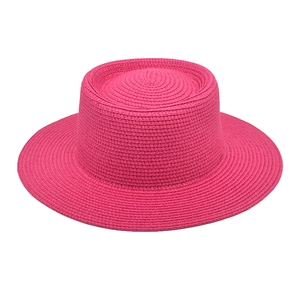 Detailansicht der Textur eines leuchtend pinkfarbenen flachen Strohhuts für den Urlaub.