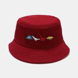 Close-up of four colorful cartoon dinosaur embroidery on a deep red cotton bucket hat