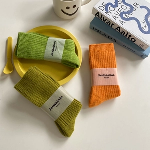 Japanese style wool slouch socks in green and orange tones with ribbed knit texture