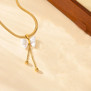 Elegant gold snake chain necklace featuring a white butterfly pendant with long tassels