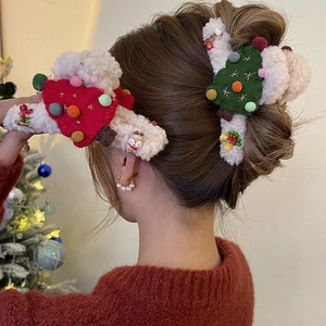 Plush Christmas hair claw clip with reindeer and tree charms on hair for holiday style