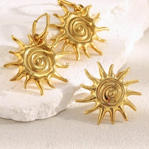 18K gold plated stainless steel sunburst earrings on a white textured stone surface