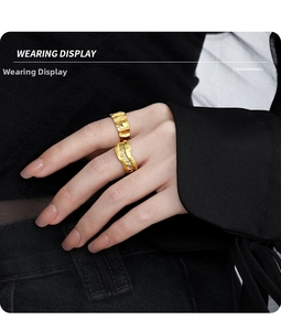 Detail of irregular texture gold rings with liquid metal style on finger