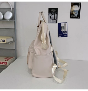 Side view of beige nylon school backpack showing multi-pocket design and side pockets