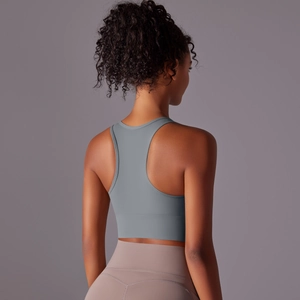 Detail view of racerback sports bra in grey with wide elastic band for support