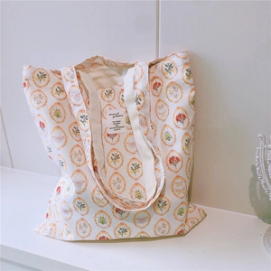 Close-up of vintage floral and butterfly print details on white canvas tote bag