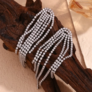 Macro shot of silver tassel earrings with 18K gold plating and shimmering zircons