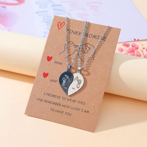 Detail der gravierten Herzanhänger für Paare auf Pinky-Promise-Karte mit warmem Hintergrund