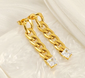 Close-up of gold chain earrings with square cubic zirconia on white satin background