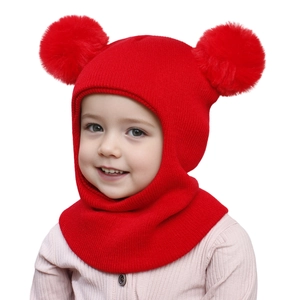 Detail of red knit baby winter hat with double pom-poms and integrated ear protectors